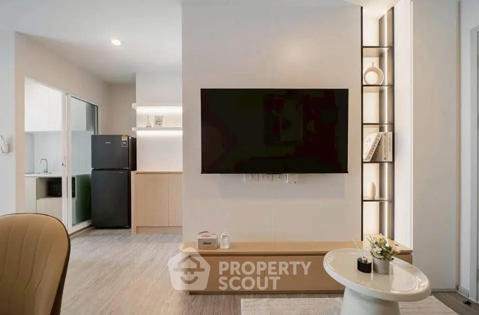 Modern living room with sleek TV setup and stylish decor in a contemporary apartment.