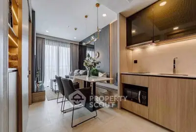 Modern open-layout kitchen and living room with stylish decor and natural light.