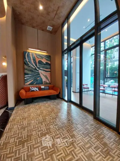 Modern interior with high ceilings and large windows, featuring stylish decor and seating area.