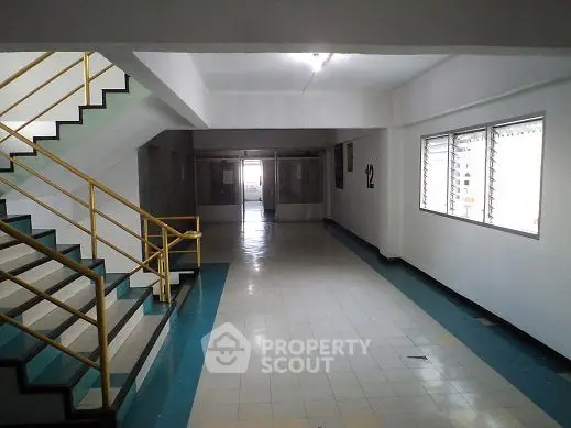 Spacious building corridor with staircase and natural light