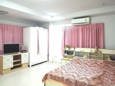 Spacious bedroom with pink curtains and modern furnishings