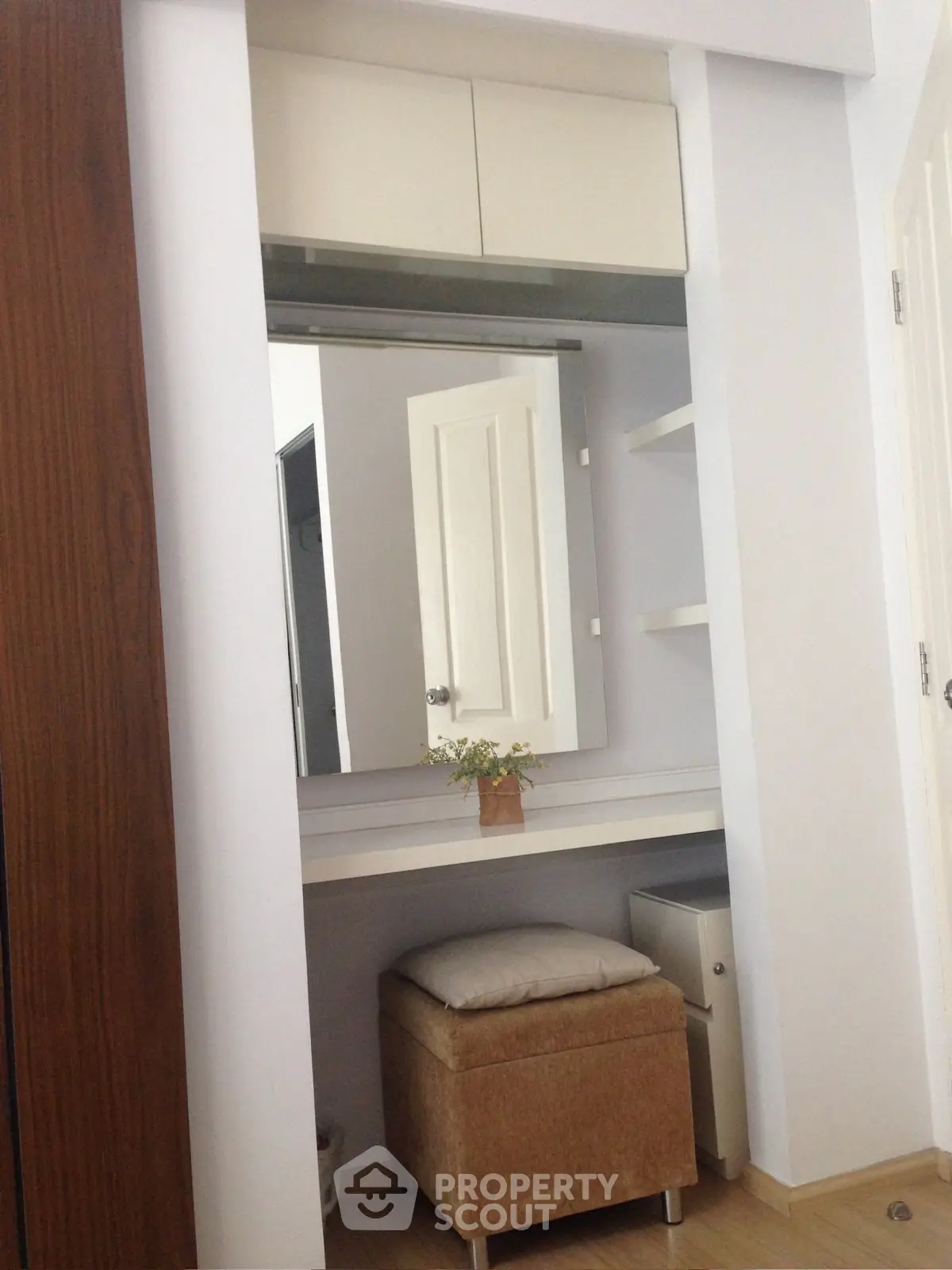 Cozy bedroom corner with a stylish vanity and storage solutions.
