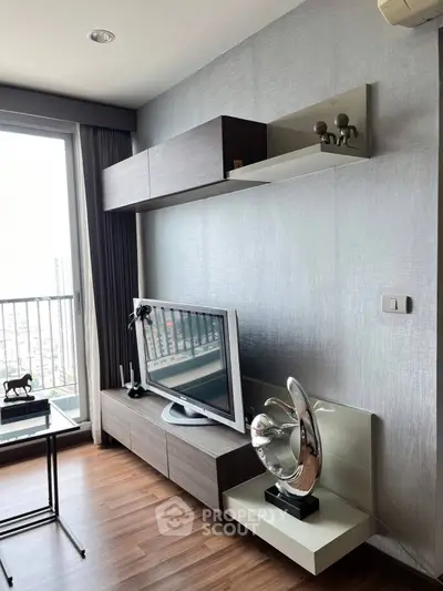 Modern living room with sleek TV unit and decorative sculpture, featuring a balcony view.