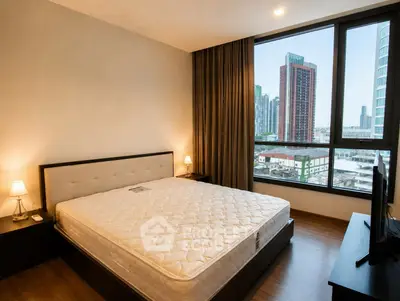 Spacious bedroom with city view and modern furnishings in luxury apartment.