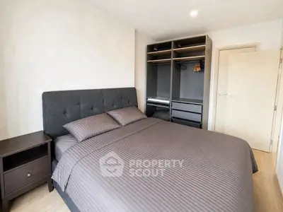 Modern bedroom with stylish gray bedding and open closet in a contemporary apartment.