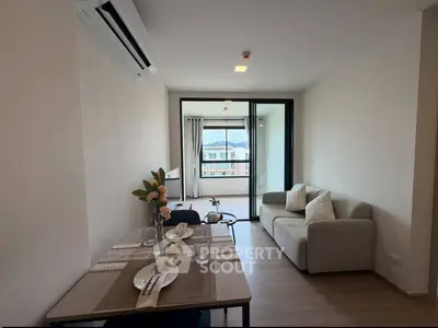 Modern living room with dining area and balcony view in a stylish apartment.