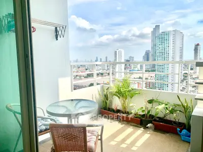 Spacious balcony with city skyline view and cozy seating area.