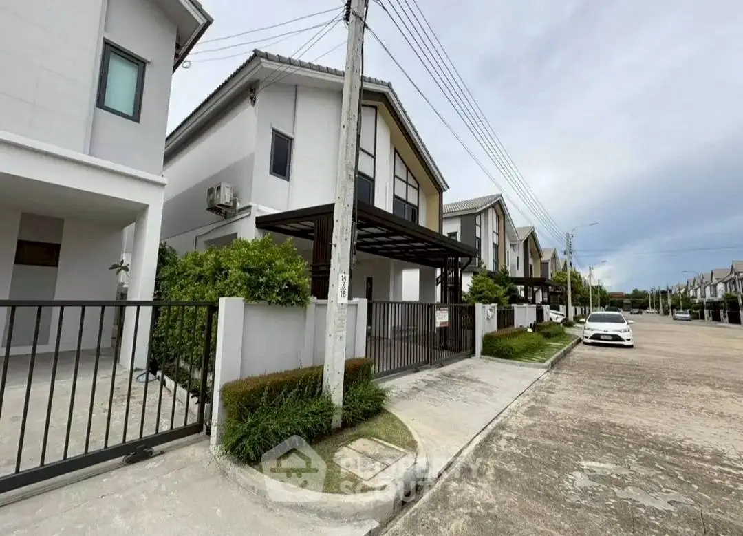 Modern suburban houses with gated driveways in a peaceful neighborhood street view.