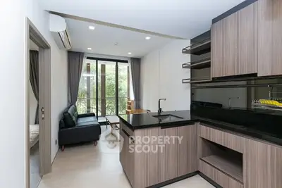 Modern open-layout kitchen with sleek cabinetry and cozy living area.
