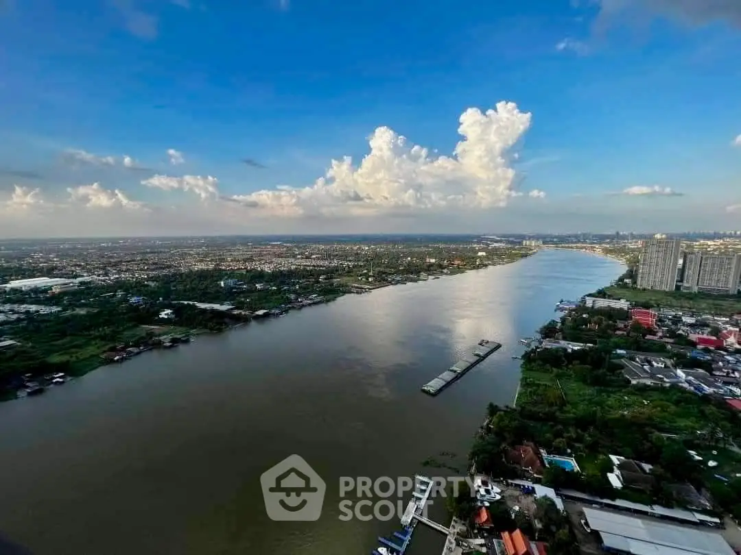 Stunning river view from high-rise building showcasing expansive cityscape and lush greenery.