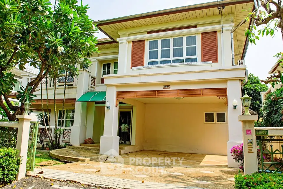 Charming two-story house with lush garden and spacious driveway in a serene neighborhood.