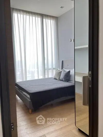 Modern bedroom with large windows and stylish decor in a high-rise apartment.