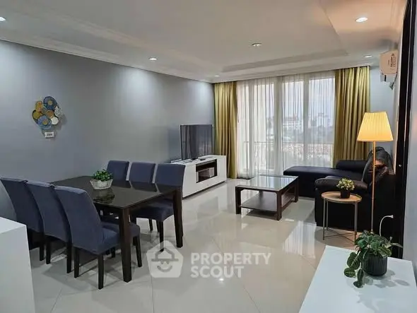 Spacious modern living room with elegant dining area and large windows for natural light.