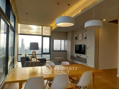 Modern living room with city view, stylish lighting, and elegant dining area.