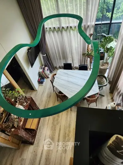 Stunning modern living room with high ceilings and large windows offering lush garden views.