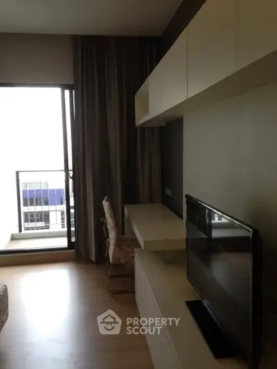 Modern living room with balcony access and sleek TV setup