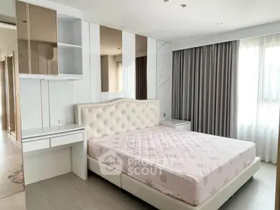 Spacious modern bedroom with elegant decor and large windows for natural light.
