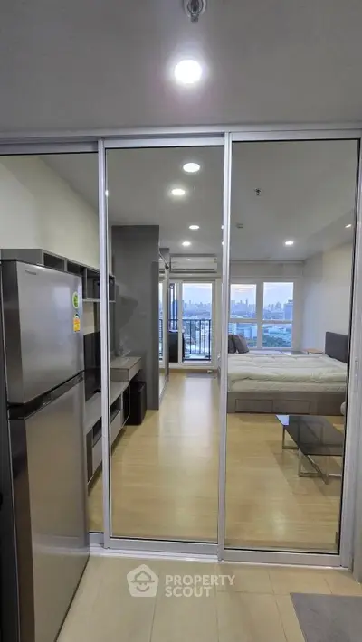 Modern studio apartment with sleek design and city view from balcony.