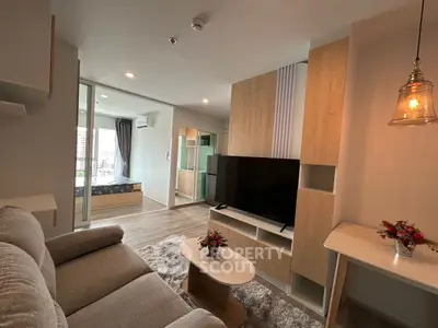 Modern living room with cozy sofa and TV, open to a stylish bedroom.