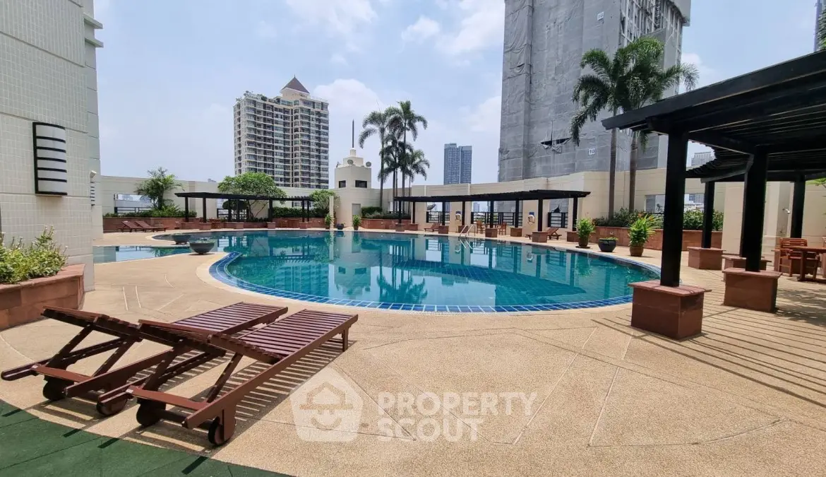 Luxurious rooftop pool with city views and lounging area in a high-rise building.