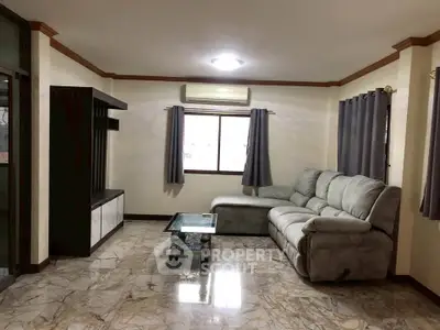 Spacious living room with marble flooring and modern furniture, perfect for relaxation and entertainment.
