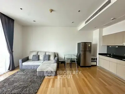 Modern living room with sleek kitchen and cozy sofa in open layout apartment.