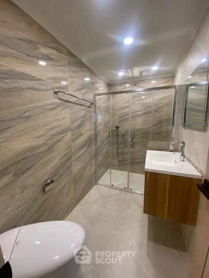 Modern bathroom with glass shower and sleek fixtures in a stylish home.