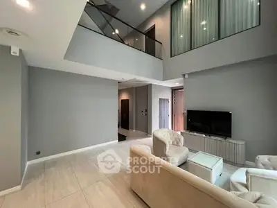 Spacious modern living room with high ceiling and elegant furnishings