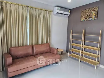 Modern living room with brown leather sofa and wooden shelves, featuring elegant curtains and air conditioning.