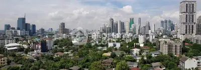 Stunning panoramic cityscape view showcasing a vibrant urban skyline with lush greenery.
