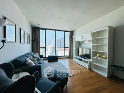 Spacious living room with city view, modern furniture, and large windows in a high-rise apartment.