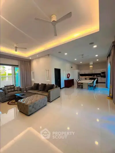 Spacious modern living room with open kitchen and elegant lighting