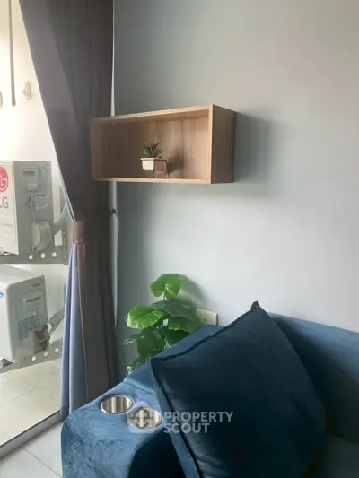 Cozy living room with modern blue sofa and stylish wall shelf