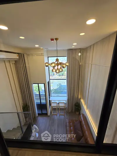 Stunning modern living room with high ceiling and large windows offering a great view, perfect for urban living.