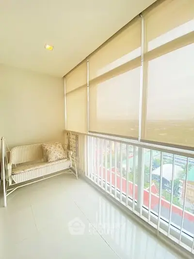 Bright balcony with city view and cozy seating area, perfect for relaxation.
