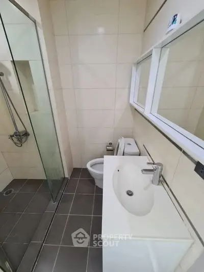 Modern bathroom with glass shower and sleek fixtures in a contemporary apartment.