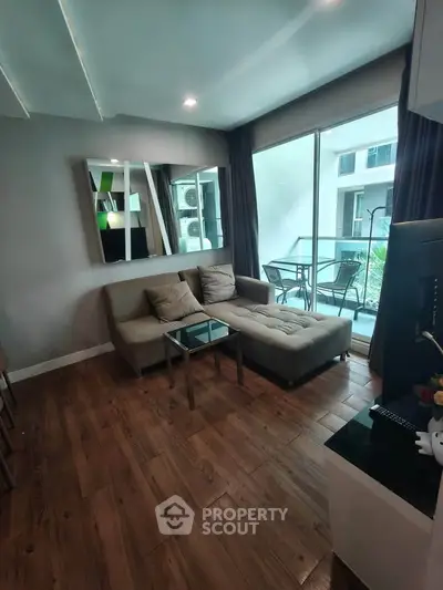 Stylish living room with modern decor and balcony view in urban apartment.