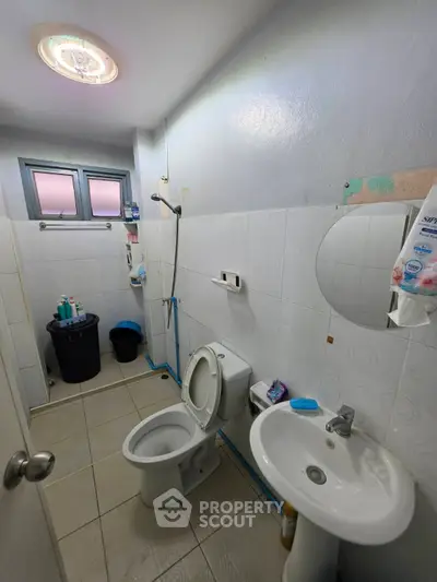 Compact bathroom with toilet, sink, and shower in a modern apartment.