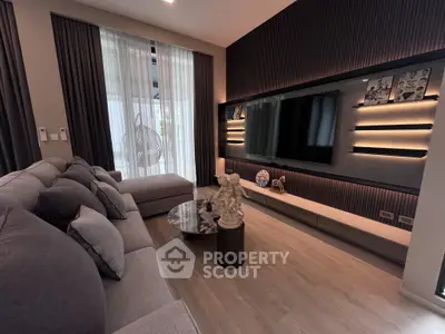 Luxurious modern living room with elegant decor and large TV, perfect for relaxation and entertainment.