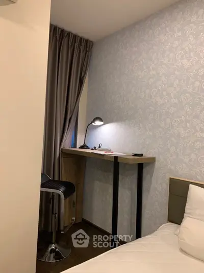 Cozy study nook with modern desk and lamp in a stylish bedroom corner.