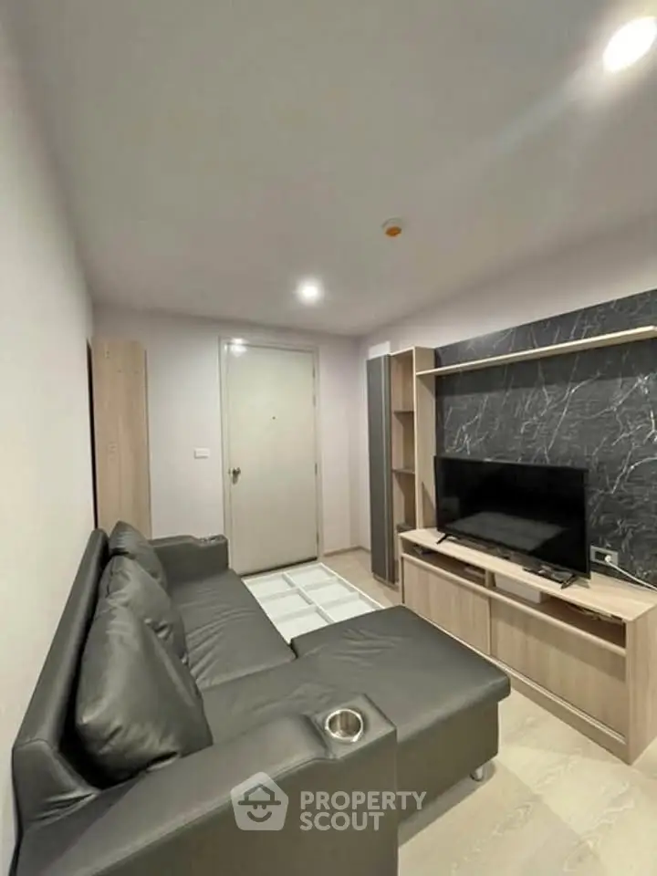 Modern living room with sleek black sofa and entertainment center