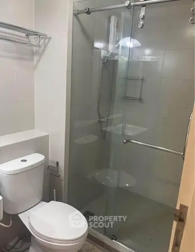Modern bathroom with glass shower enclosure and sleek fixtures.