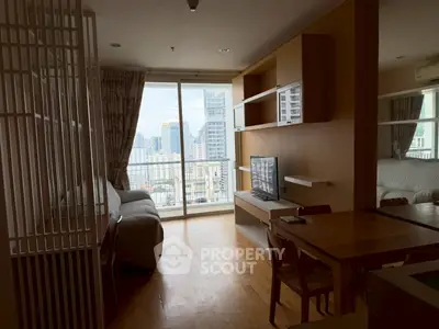 Modern living room with city view, featuring sleek furniture and large windows for natural light.