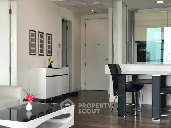 Modern living room with sleek furniture and open layout, featuring a stylish dining area and contemporary decor.