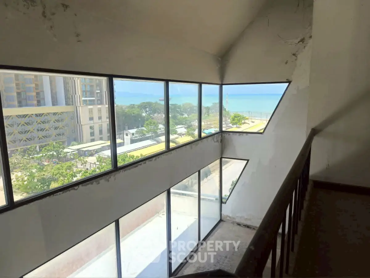 Stunning ocean view from modern high-rise building with expansive windows and unique architectural design.