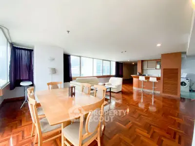 Spacious open-plan living and dining area with modern furnishings and large windows.
