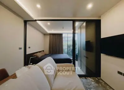 Modern studio apartment with cozy living area and bedroom, featuring sleek design and ambient lighting.