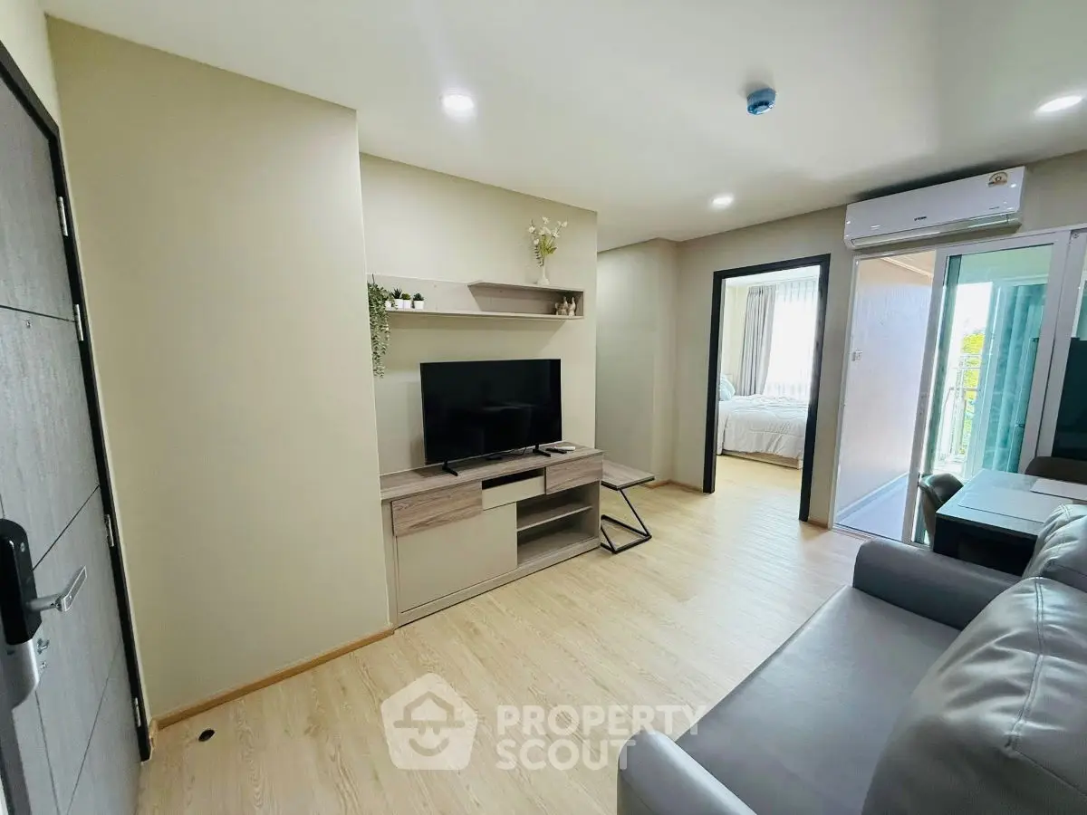 Modern living room with sleek TV setup and cozy bedroom view