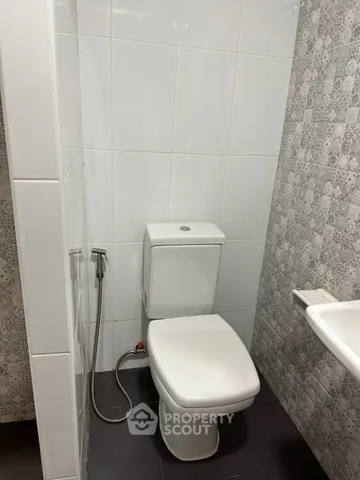 Modern bathroom with sleek white tiles and contemporary fixtures.