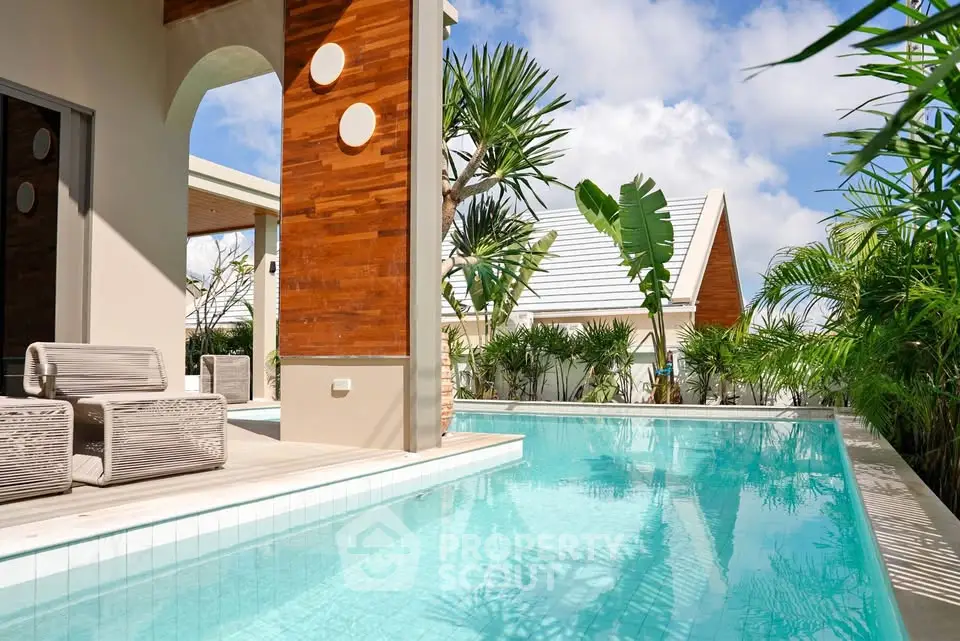 Luxurious tropical poolside with modern architecture and lush greenery.